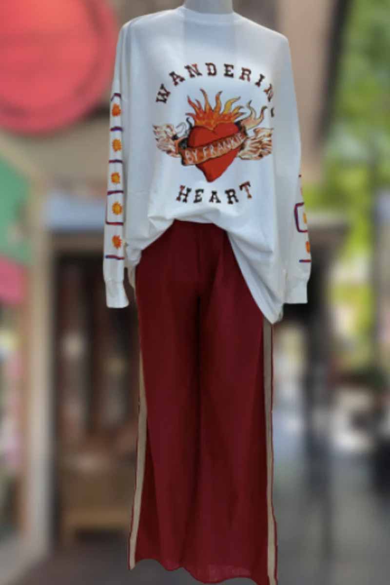 by frankie long sleeve white shirt with wandering heart print & heart with flames on front and print down the sleeve front view