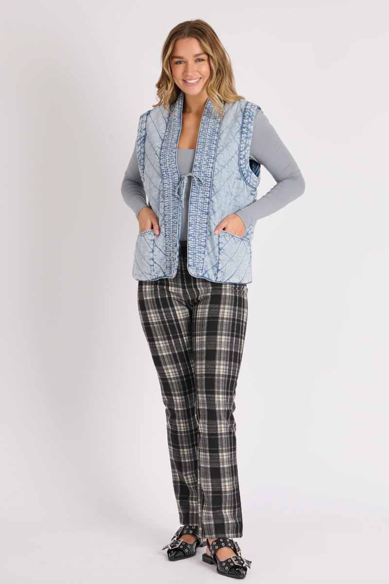 ellis & dewey quilted vest puff like fabric in a light denim look fabric. ties at the front. Full view of outfit