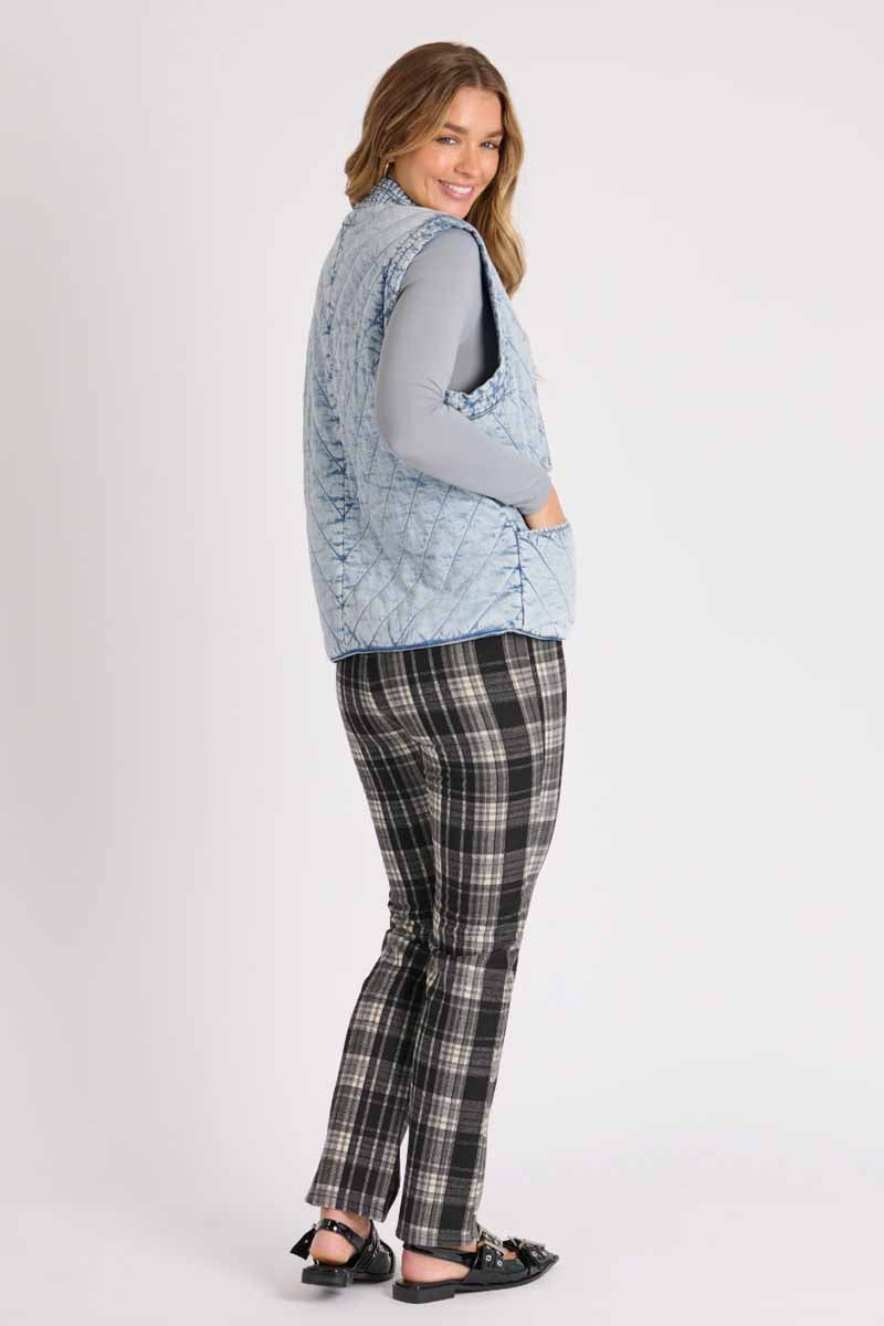 ellis & dewey quilted vest puff like fabric in a light denim look fabric. ties at the front. side view of outfit