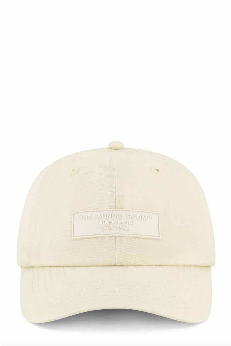 The laundry room trucker hat with patch branding on from bone white colour 